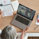 Senior woman employer hr holding job interview by video call, top view.