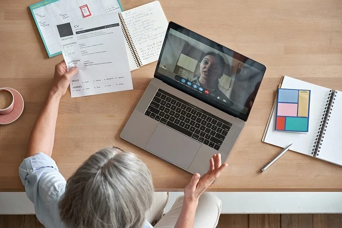 Senior woman employer hr holding job interview by video call, top view.
