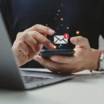 Hand of businessman using smartphone for email with notification alert.