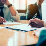 Boardroom with human resource business people writing on paper w