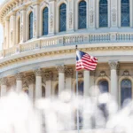 US Congress dome closeup with background of water fountain splashing, American flag waving in Washington DC, USA closeup on Capital capitol hill, columns, pillars, nobody