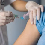 nurse giving a vaccine to a patient. Close-up
