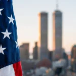 American flag with blurred World Trade Center Twin Towers background for Patriot Day remembrance
