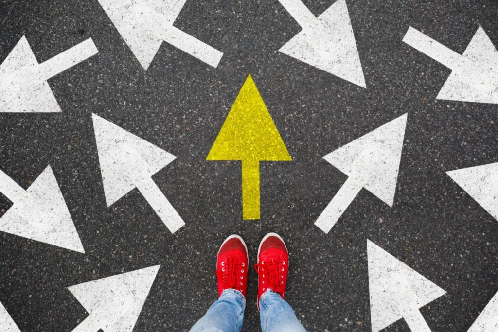Person standing on the road to future life with many direction sign point in different ways and only yellow one. Decision making is very hard, but you have a choice and right way